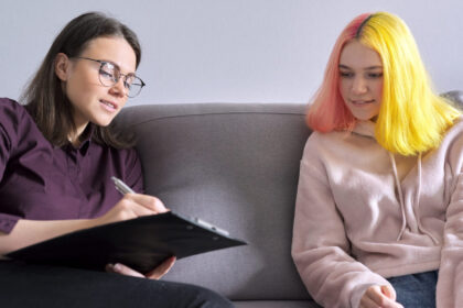 Psycholoog maakt aantekeningen tijdens haar gesprek met een tienermeisje.